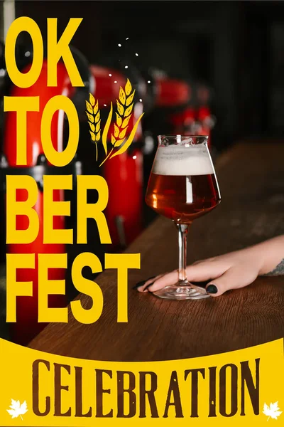 Обрезанный снимок человеческой руки со стаканом свежего пива в баре с надписью 