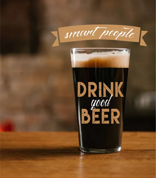 Close-up view of glass with delicious dark beer on table in pub with 