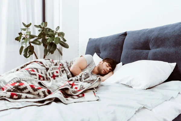 Selective focus of young man sleeping in bed at home — Stock Photo