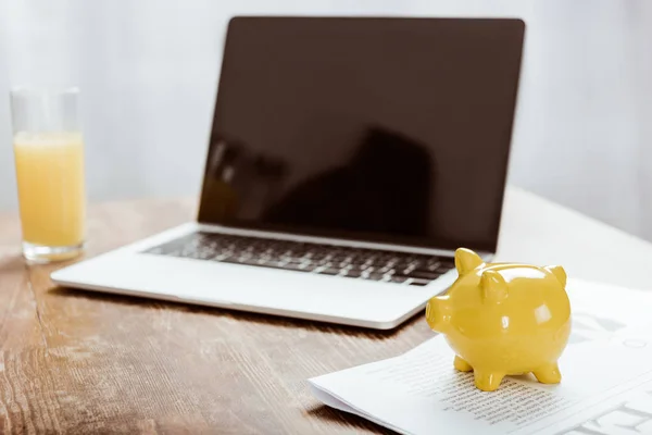 Banco piggy amarelo e laptop com tela em branco na mesa — Fotografia de Stock