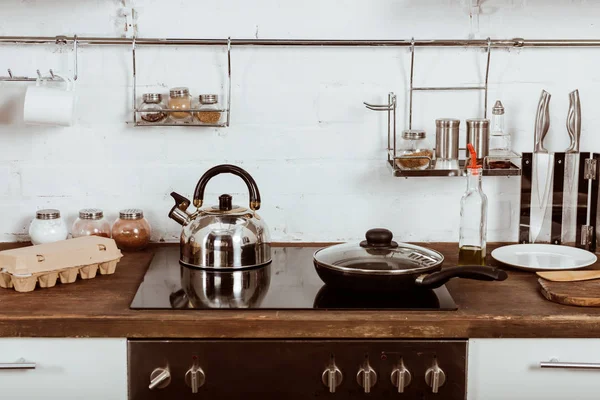 Selective focus of modern kitchen interior with frying pan and teapot on stove — Stock Photo