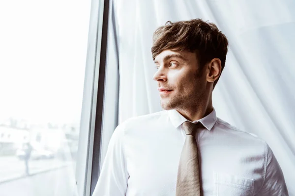 Retrato de homem de negócios em camisa branca e gravata pescoço olhando para longe no escritório — Fotografia de Stock