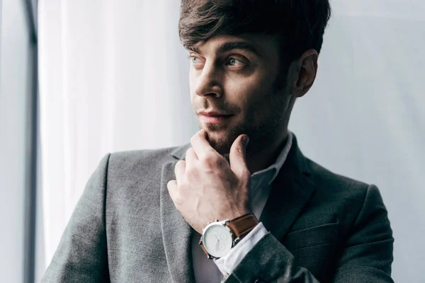 Portrait of thoughtful young businessman with watch looking away — Stock Photo