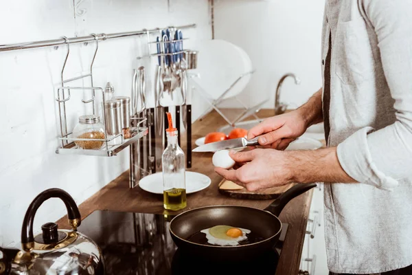 Abgeschnittenes Bild eines jungen Mannes, der beim Frühstück in der Küche Rührei kocht — Stockfoto