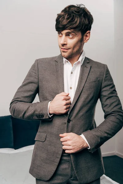 Handsome cheerful businessman putting on jacket — Stock Photo