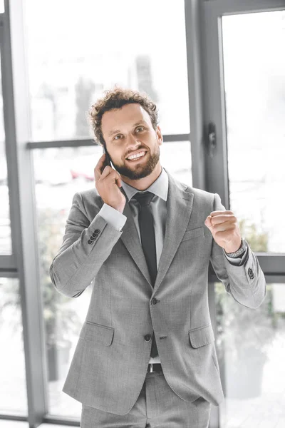 Portrait Young Excited Businessman Talking Smartphone Office — Free Stock Photo