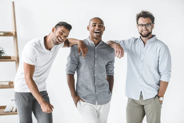 Groupe multiethnique de jeunes hommes d'affaires souriants debout dans un bureau léger — Photo de stock