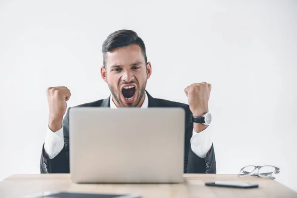 Portrait of excited businessman looking at laptop screen at workplace isolated on white — Stock Photo