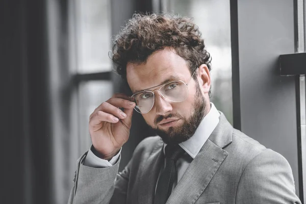 Retrato de hombre de negocios con estilo de confianza en gafas y traje mirando a la cámara - foto de stock