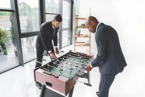 Des hommes d'affaires concentrés jouant au baby-foot au bureau — Photo de stock