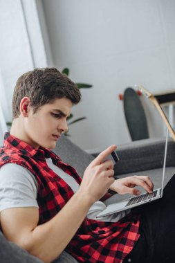Genç evde laptop ve kredi kartı kullanma