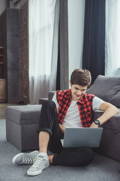 Adolescente Bonito Usando Laptop Enquanto Sentado Chão Perto Sofá — Fotografia de Stock