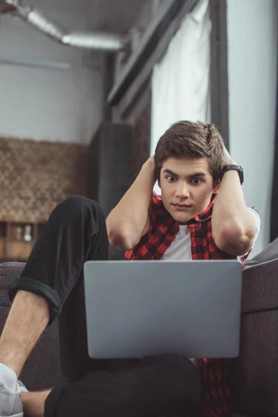 Zszokowany Nastolatek Patrząc Laptopie Siedząc Podłodze — Zdjęcie stockowe
