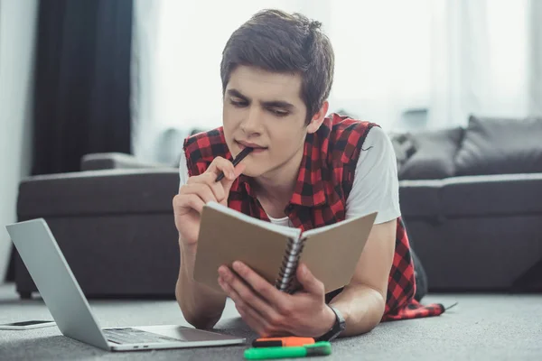 Pensive Teenager Studying Copybook Laptop While Lying Floor — Stock Photo, Image