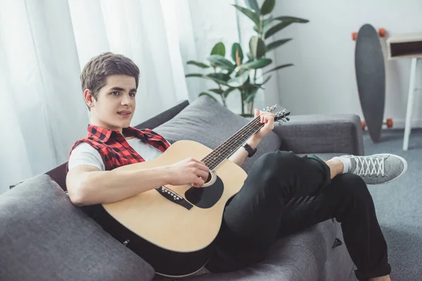 Adolescente Jovem Tocando Guitarra Acústica Sofá — Fotografia de Stock