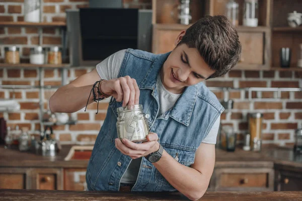 Smiling Teenager Taking Dollar Banknotes Saving Glass Jar Money — Stock Photo, Image