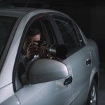 Manliga infiltratör gör övervakning av kameran från bil