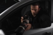 Paparazzi sehen sich Fotos mit Objektglas an und überwachen sie vom Auto aus 