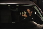 Paparazzi überwachen sein Auto mit einer Kamera 
