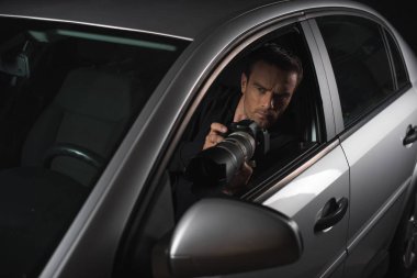 Erkek paparazzi gözetim kamera ile nesne camı arabasından yapıyor 
