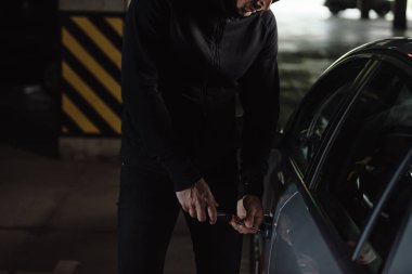 atış erkek soyguncu siyah hoodie izinsiz arabaya tornavida tarafından kırpılmış. 