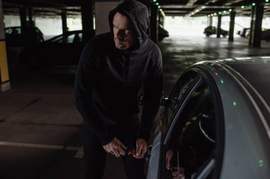 siyah hoodie araba tornavida tarafından rahatsız dikkatli erkek soyguncu 
