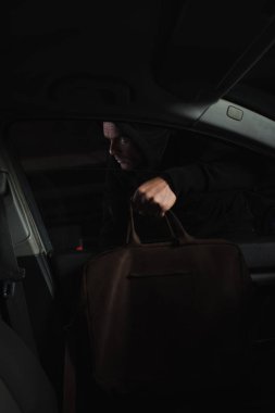 siyah hoodie araba çantasından hırsızlık dikkatli erkek hırsız