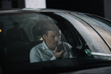 gözetleme yapıyor ve arabaya walkie talkie kullanarak gizli erkek Ajan