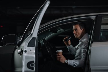 gizli erkek Ajan ile kahve gözetleme dürbünü tarafından arabadan yapıyor.