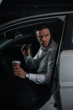 Gözetleme dürbünü tarafından yapıyor ve kağıt bardak kahve holding ciddi erkek gizli ajan