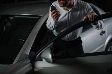 Erkek gizli ajan car yakınındaki walkie talkie kullanarak görüntü kırpılmış 