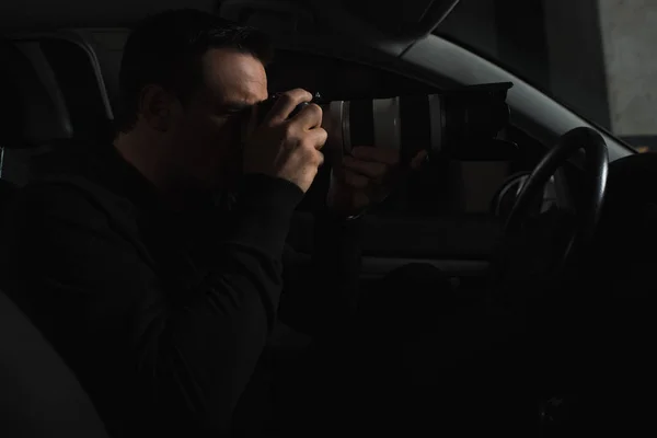 彼の車からオブジェクト ガラス カメラによる監視を行って集中して男の側面図 — ストック写真