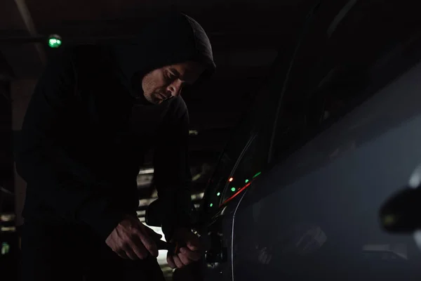 重点男子劫匪在黑色帽衫侵入汽车用螺丝刀 — 免费的图库照片
