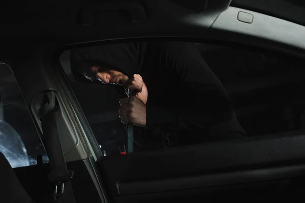 男子劫匪在黑色帽衫侵入汽车的撬棍 — 图库照片