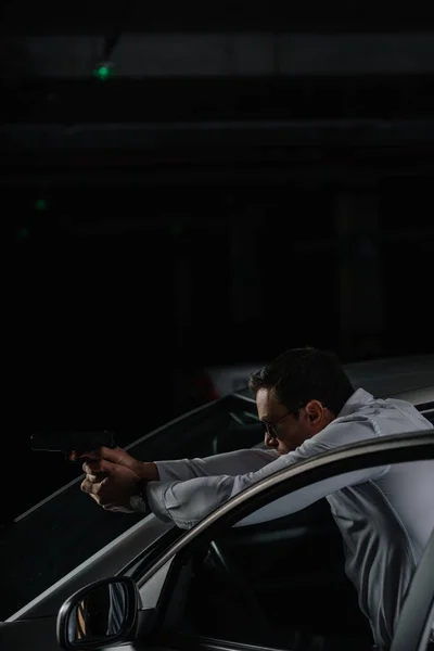 Agente Masculino Encubierto Gafas Sol Pie Cerca Del Coche Apuntando — Foto de stock gratuita