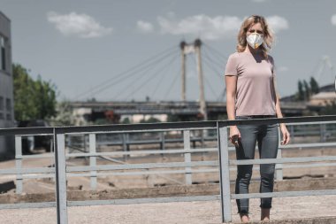 woman in protective mask standing on bridge, air pollution concept clipart