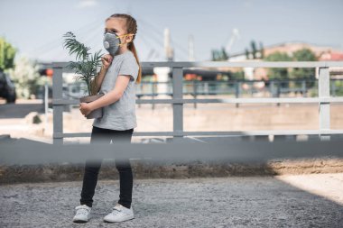 Çocuk koruyucu maske yeşil taşıyan bitki, hava kirliliği kavramı saksı
