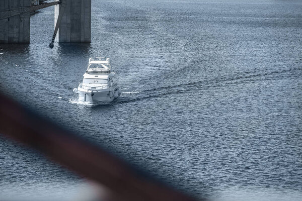 white ship sailing on blue river to harbor