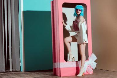 Genç kadında moda: mavi peruk dekoratif pembe kutu yay ile poz 