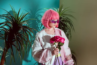gül tutan ve uzağa bakarak pembe peruk güzel moda kadın modeli