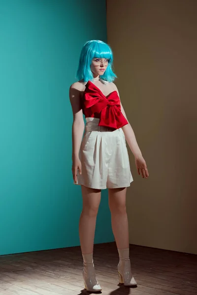 Fashionable Female Model Blue Wig Red Bow Looking Away Studio — Free Stock Photo