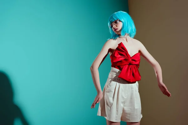 时尚女孩在蓝色假发和红色弓摆在演播室 — 图库照片