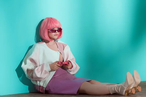 时尚漂亮的女孩在粉红色的假发坐在地板上 使用游戏杆 — 图库照片