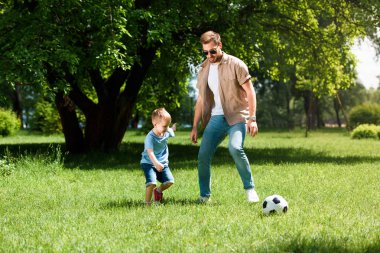Baba ve oğul Park'ta çim futbol oynamak