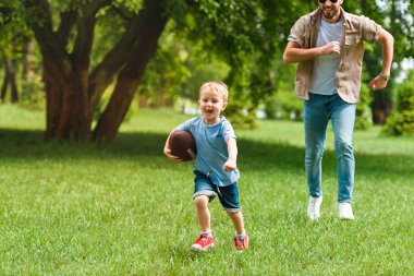 mutlu baba ve oğul park adlı Amerikan futbolu topu ile çalışan