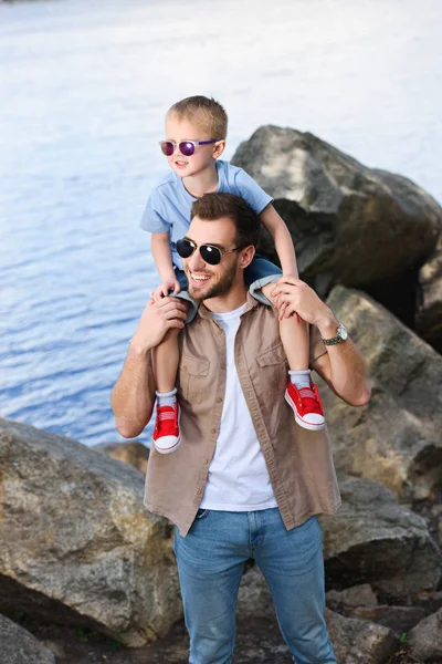 Happy father holding son on shoulders and they looking away at park — Stock Image Happy Father Holding Son Shoulders Looking Away Park Stock Photo