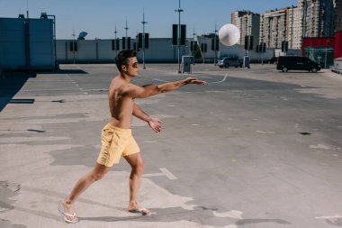 Park plaj voleybolu oynarken gömleksiz yakışıklı genç