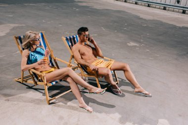 Genç çift rahatlatıcı yüksek açılı görünüş Park üzerinde rahatlatıcı şezlong üzerinde