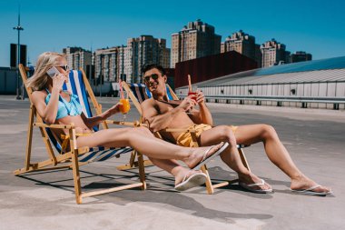 şezlong üzerinde Park üzerinde otururken kokteyller gözlüklü genç çift