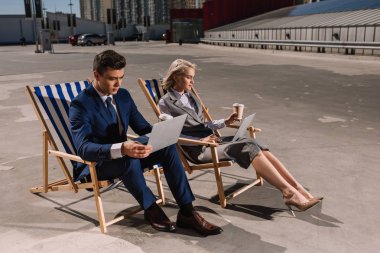 young business people working with laptop while sitting on sun loungers on parking clipart